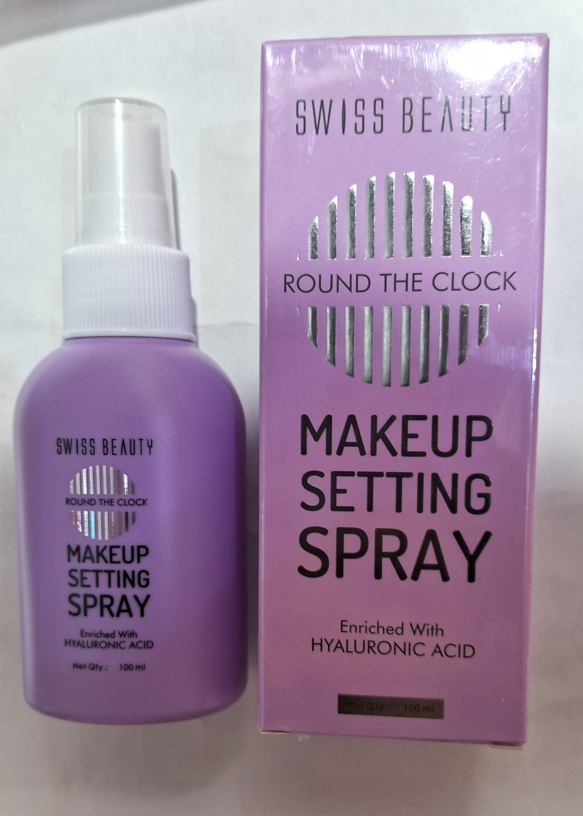 Makeup setting spray bottle and packaging on a surface